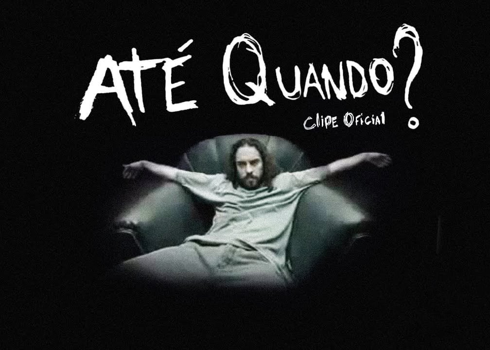 Fundo preto com o texto em branco bem grande de 'Até Quando?' e em letras menores aparece 'Clipe Oficial'. Gabriel o Pensador aparece 'jogado' em um sofá, com os braços abertos.