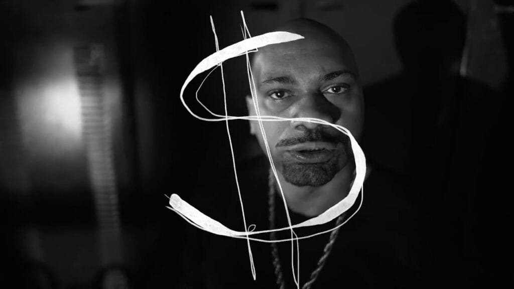 A imagem em preto e branco mostra MV Bill com a cabeça raspada e barba curta, olhando diretamente para a câmera. Um grande símbolo de cifrão ('$') estilizado em branco está sobreposto em primeiro plano, cobrindo parte do rosto do rapper. O fundo é escuro e desfocado, com algumas luzes indistintas visíveis.