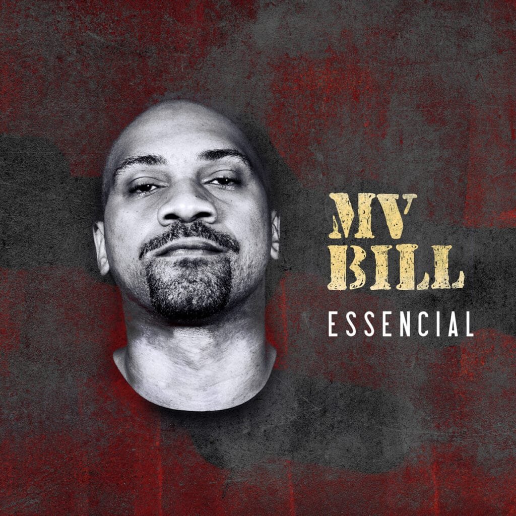 Capa de álbum com MV Bill centralizado na parte esquerda. Ele tem a cabeça raspada e uma barba bem cuidada, olhando diretamente para a frente com uma expressão neutra. O fundo da imagem é uma parede com textura rugosa, em tons escuros de vermelho e marrom, que parece desgastada ou com um aspecto envelhecido. No lado direito da imagem, há texto em duas linhas. A primeira linha, em letras amarelas com uma textura que simula madeira ou desgaste, diz 'MV BILL'. A segunda linha, abaixo e em letras brancas menores, diz 'ESSENCIAL', nome do disco.