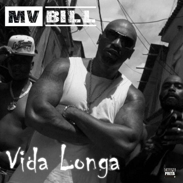 A imagem é em preto e branco e mostra o rapper brasileiro MV Bill em primeiro plano, usando óculos de sol e uma regata branca. Ele está com os braços cruzados e o olhar fixo. Ao fundo, parcialmente visíveis, estão outras duas pessoas e o que parece ser um cenário urbano com edifícios. A parte superior da imagem exibe 'MV BILL' em letras maiúsculas. Na parte inferior, lê-se 'Vida Longa' em uma fonte estilizada. Há também um pequeno logotipo no canto inferior direito que diz 'CHAPA PRETA'.