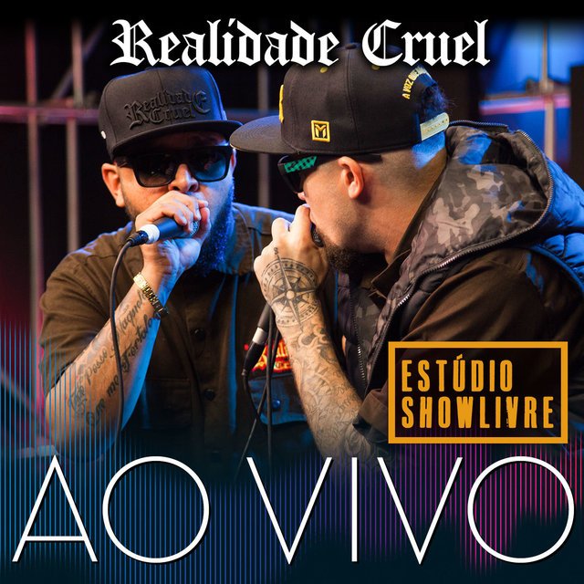 Dois rappers brasileiros do grupo Realidade Cruel, um usando boné de aba reta da marca 'Realidade Cruel' e segurando um microfone, e o outro de boné com o logo 'M' de aba reta, com braços tatuados, segurando um microfone e com uma jaqueta camuflada. Ambos usam óculos escuros. A imagem é em tons escuros e azuis, com um letreiro branco na parte superior escrito 'Realidade Cruel' e um letreiro azul na parte inferior escrito 'AO VIVO'. No canto inferior direito há um selo amarelo com a inscrição 'ESTÚDIO SHOWLIVRE'.