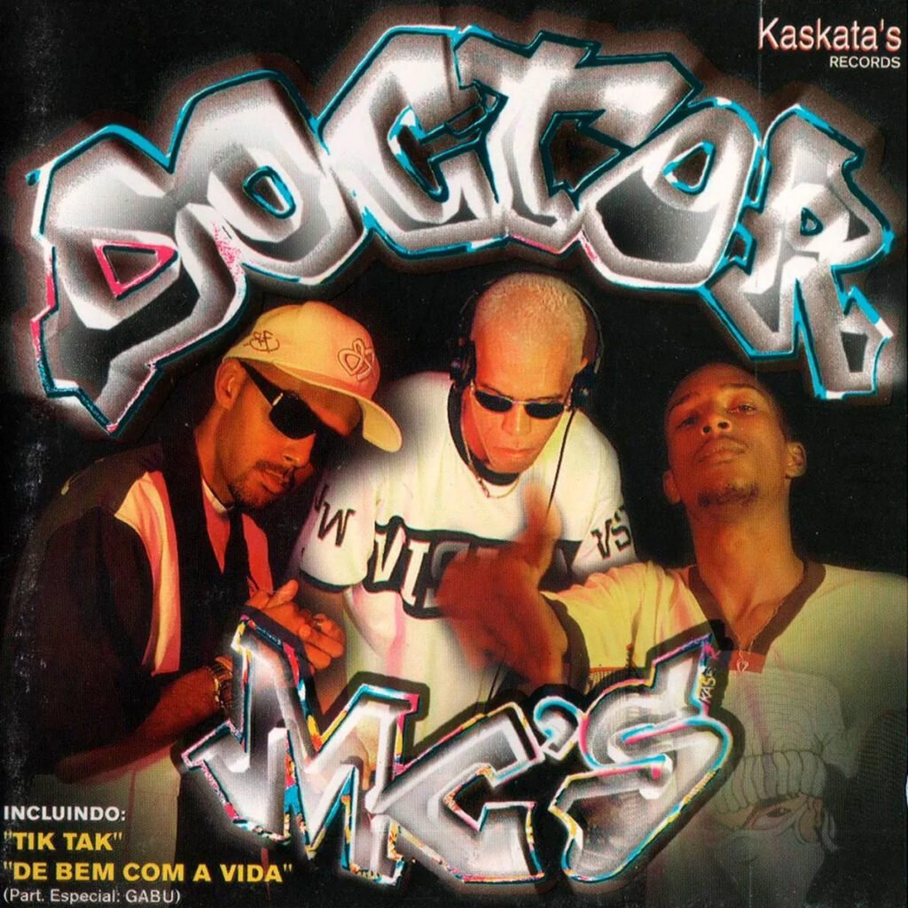 A capa do álbum 'Agora a Casa Cai' do grupo Doctor MC's é um ícone visual do rap brasileiro dos anos 90, dominada por uma estética de grafite agressiva, onde o nome do grupo é estilizado com letras prateadas e delineamentos azuis em 3D sobre um fundo escuro. MC A., Smokey Dee e Dog Jay aparecem no centro, sob iluminação dramática, com vestimentas e acessórios típicos da cultura Hip Hop — bonés virados, óculos de sol e correntes — transmitindo uma atitude de rua. A capa também destaca, no canto superior direito, o selo Kaskata's Records e, no inferior esquerdo, as faixas de sucesso 'Tik Tak' e 'De Bem Com a Vida'.