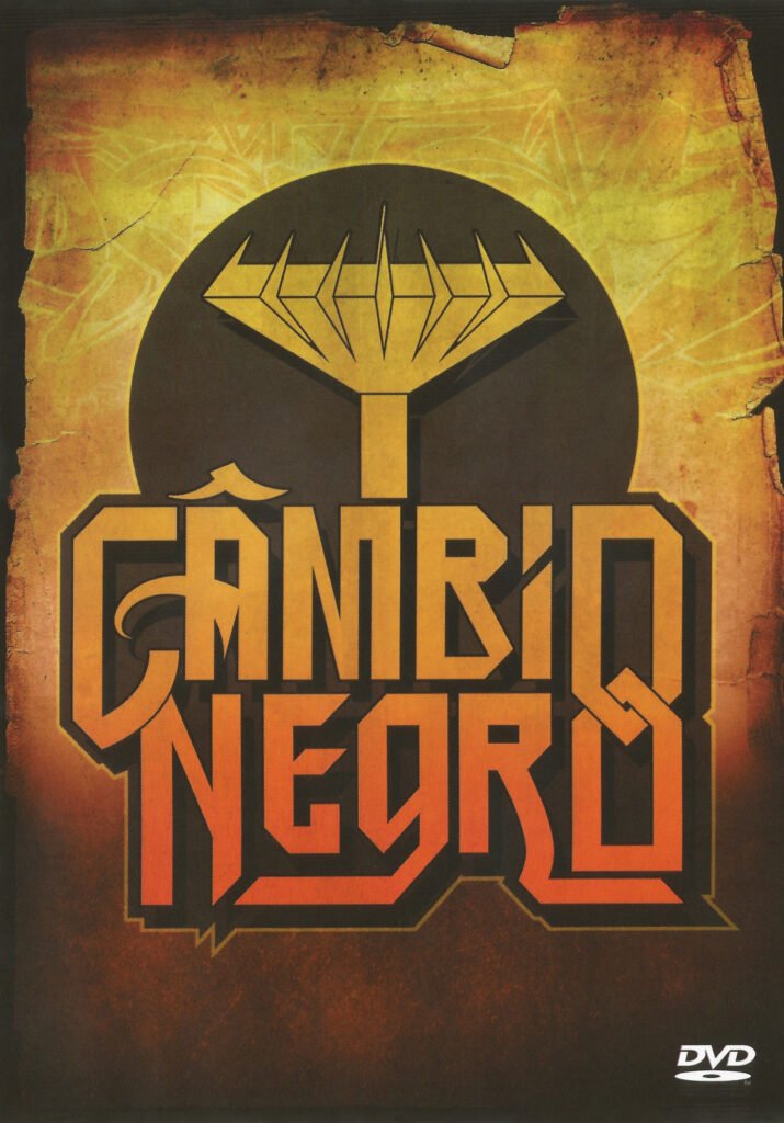 Capa do DVD 'Câmbio Negro Ao Vivo'. O nome 'CÂMBIO NEGRO' está centralizado em letras maiúsculas estilizadas, com 'CÂMBIO' sobre 'NEGRO', em um degradê do laranja para o amarelo. Acima do nome, há um símbolo geométrico amarelo dentro de um círculo marrom escuro. O fundo tem uma textura de papel envelhecido ou pergaminho em tons de marrom e amarelo, com bordas escuras e desgastadas.