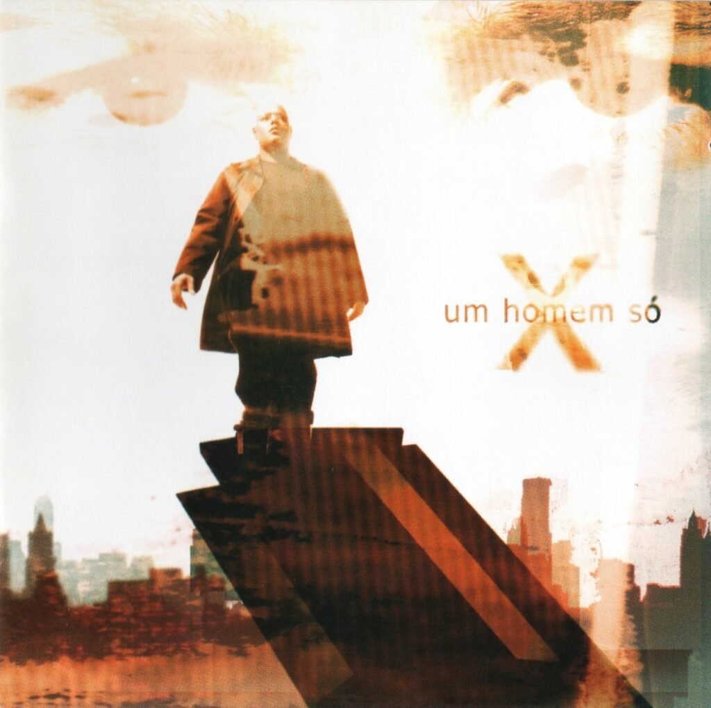 Capa do álbum solo do rapper X, intitulado 'Um Homem Só'. A imagem mostra o artista em pé no topo de uma estrutura inclinada que parece um monumento ou o topo de um prédio. Ele veste um sobretudo escuro e olha para o alto. O fundo é composto por uma paisagem urbana com prédios, utilizando tons de sépia, laranja e branco com um efeito de sobreposição e transparência. No centro à direita, lê-se o título 'um homem só' em letras minúsculas, posicionado ao lado de uma letra 'X' grande e amarela.