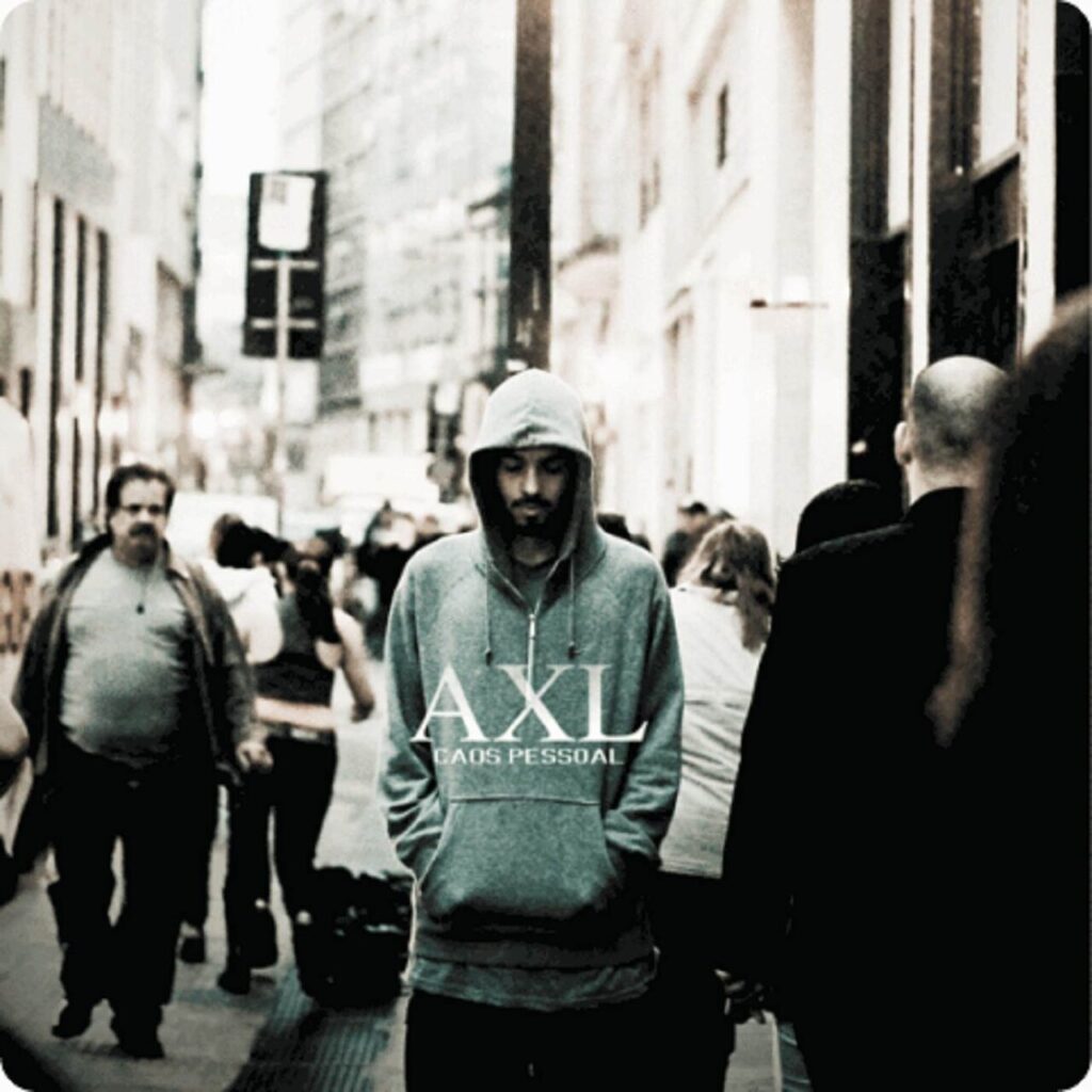 Capa de álbum com uma paleta de cores dessaturada e tons esverdeados, retratando uma cena urbana. No centro, A.X.L., um homem de pele clara e barba, caminha em direção à câmera por uma rua de cidade lotada. Ele veste um moletom cinza com o capuz cobrindo a cabeça, olha para baixo e mantém as mãos no bolso frontal da blusa. O fundo está ligeiramente desfocado, mostrando várias pessoas caminhando em diferentes direções e prédios altos nas laterais. No centro da imagem, sobreposto ao peito do homem, lê-se 'AXL' em letras brancas grandes e elegantes, e logo abaixo, 'CAOS PESSOAL' em letras brancas menores.