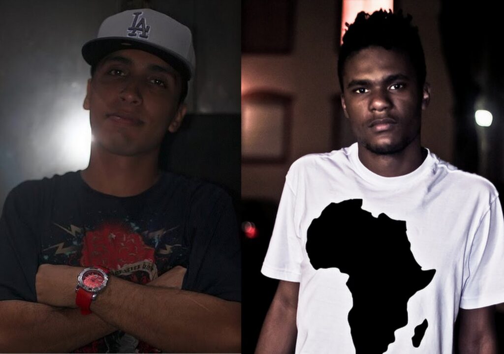 Uma imagem dividida apresenta os rappers Rashid e Terra Preta em retratos individuais lado a lado. À esquerda, Rashid usa um boné cinza com o logotipo 'LA', camiseta escura e um relógio de pulso vermelho em destaque enquanto posa de braços cruzados. À direita, Terra Preta veste uma camiseta branca estampada com o mapa do continente africano em preto, mantendo uma expressão séria.