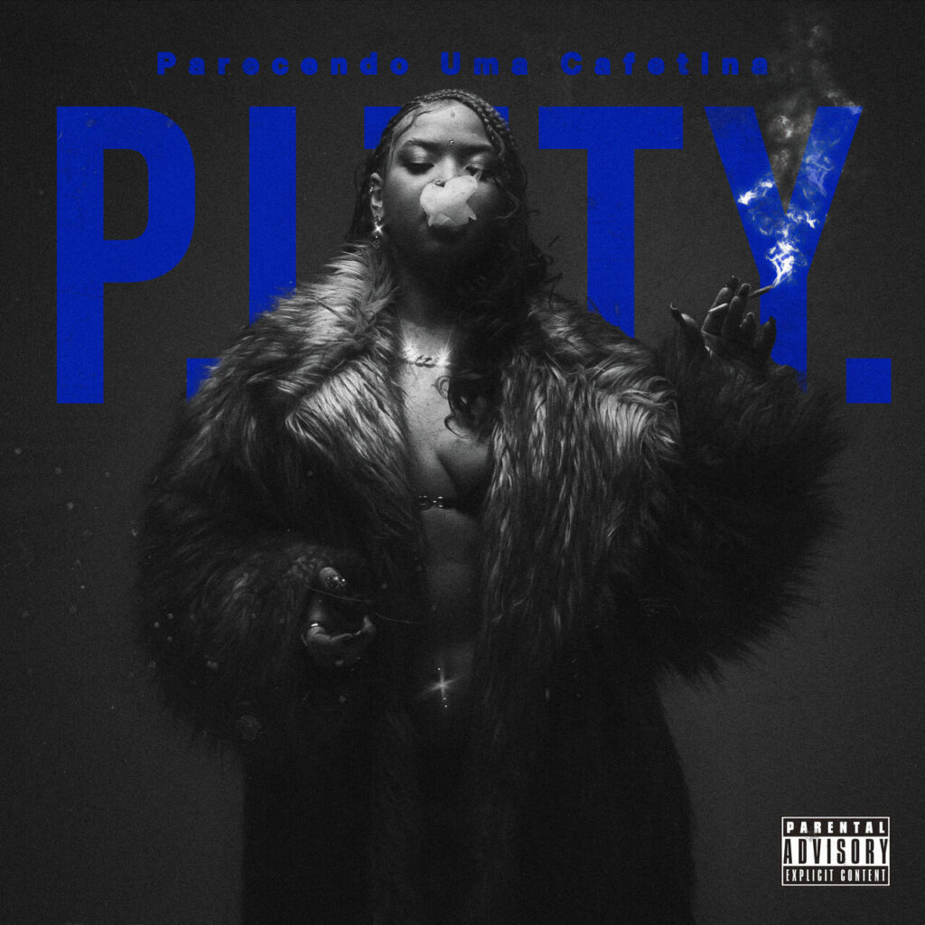 A capa do single 'P.I.T.T.Y. (Parecendo Uma Cafetina)', da artista NandaTsunami, é em preto e branco com detalhes em azul-vivo. A imagem traz um enquadramento de meio-corpo da artista em plano frontal, vestindo um casaco de pele volumoso, felpudo e escuro sobre o peito entreaberto. Ela segura um cigarro entre os dedos da mão esquerda levantada, soltando uma fumaça densa que encobre parte de seu rosto. Seu cabelo está trançado e ela usa brincos e correntes prateadas. Ao fundo, em tom azul-azulão e fonte maiúscula marcante, destaca-se a palavra 'P.I.T.T.Y.'. Logo acima da palavra principal, também em azul, lê-se o complemento do título 'Parecendo Uma Cafetina'. No canto inferior direito, há o aviso quadrado de conteúdo explícito 'PARENTAL ADVISORY EXPLICIT CONTENT'.